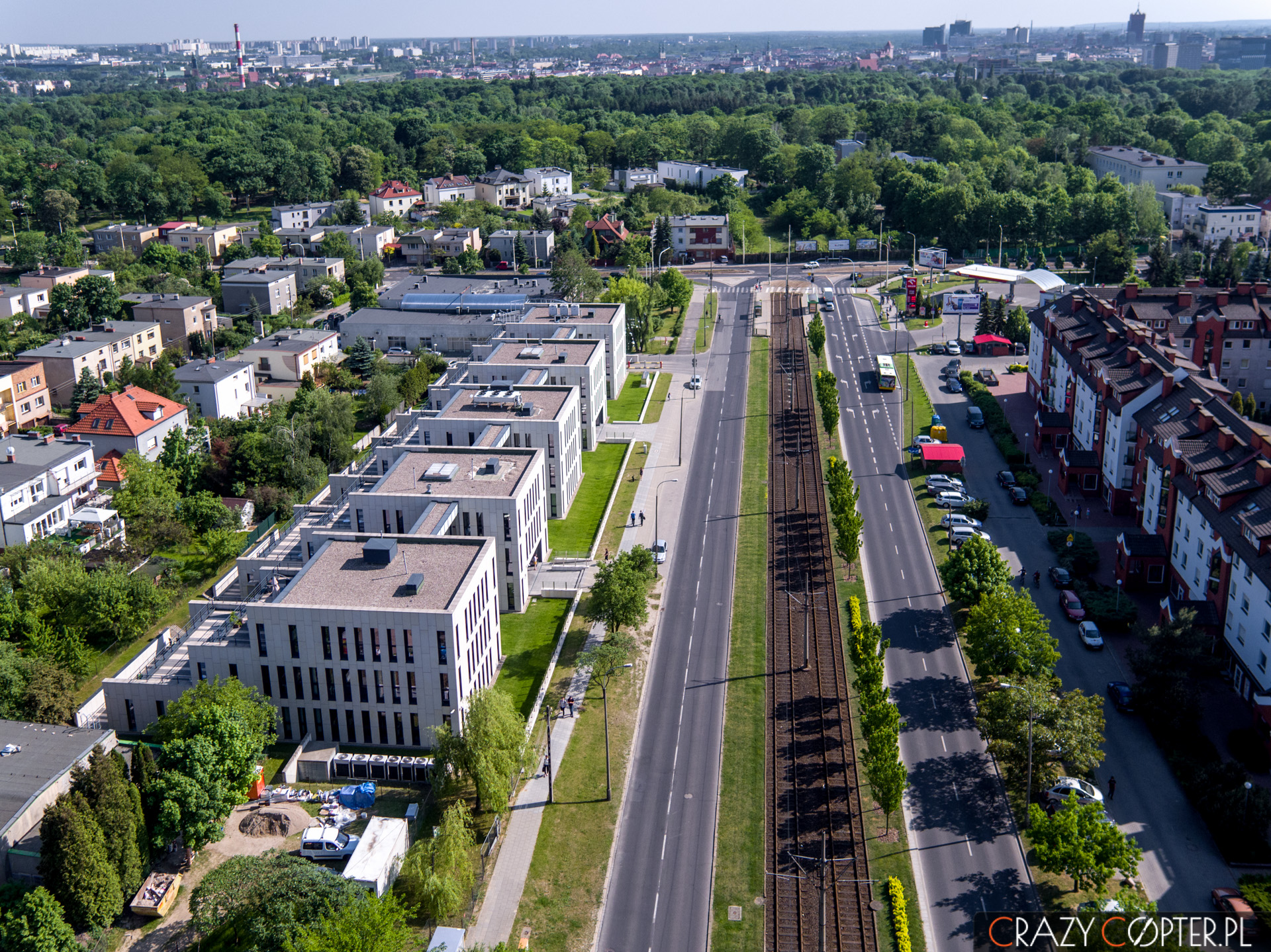 Zdjęcia nieruchomości z drona pokazują nie tylko budynek, ale i atrakcyjne otoczenie. Tutaj linia tramwajowa wraz z przystankiem autobusowym oraz zielenią w postaci parku miejskiego.
